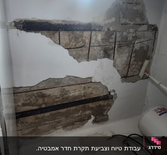 קיר עם טיח מתקלף וגליל צבע לבן